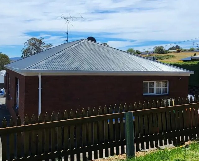 Freshly painted metal roof improving durability on a home in George Town